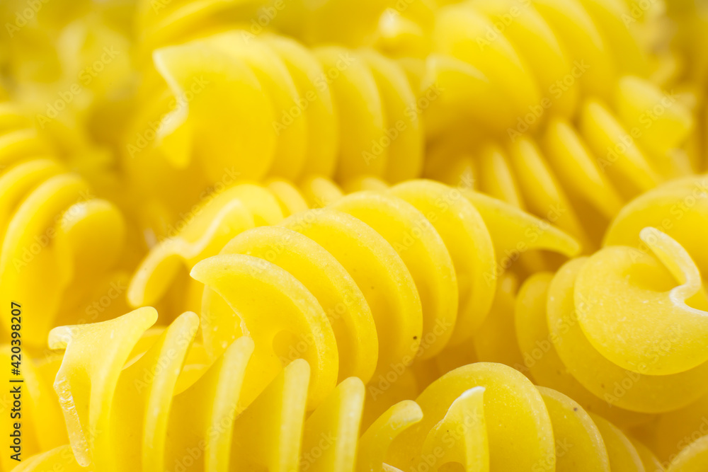 Close up uncooked spiral pasta fusilli background. Close up uncooked spiral pasta fusilli background.