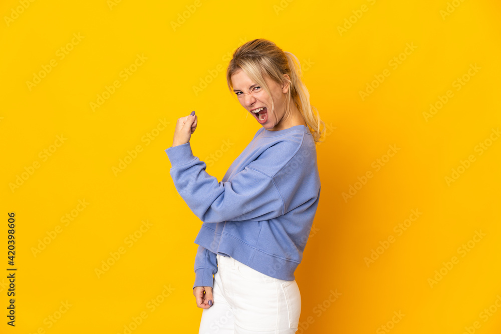 Young Russian woman isolated on yellow background celebrating a victory