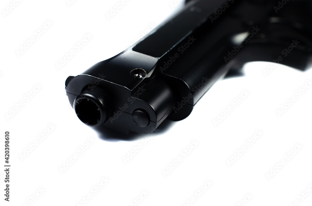 Barrel of a black gun, pistol lies on a white background. Close up. Barrel of a black gun, pistol lies on a white background. Close up.
