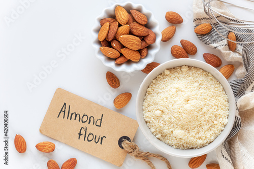 Photography Almond flour and unpeeled almonds with a whist and an empty tag for your text