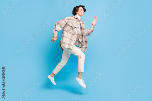 Profile full size photo of optimistic cool lady run wear shirt trousers sneakers isolated on teal color background