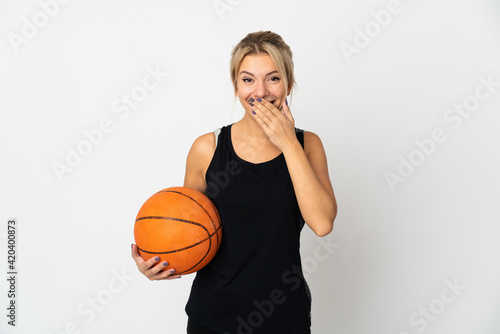Young Russian woman playing basketball isolated on white background happy and smiling covering mouth with hand