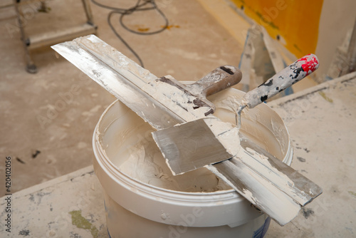 Dirty Spatula and Scraper are on a bucket of putty.