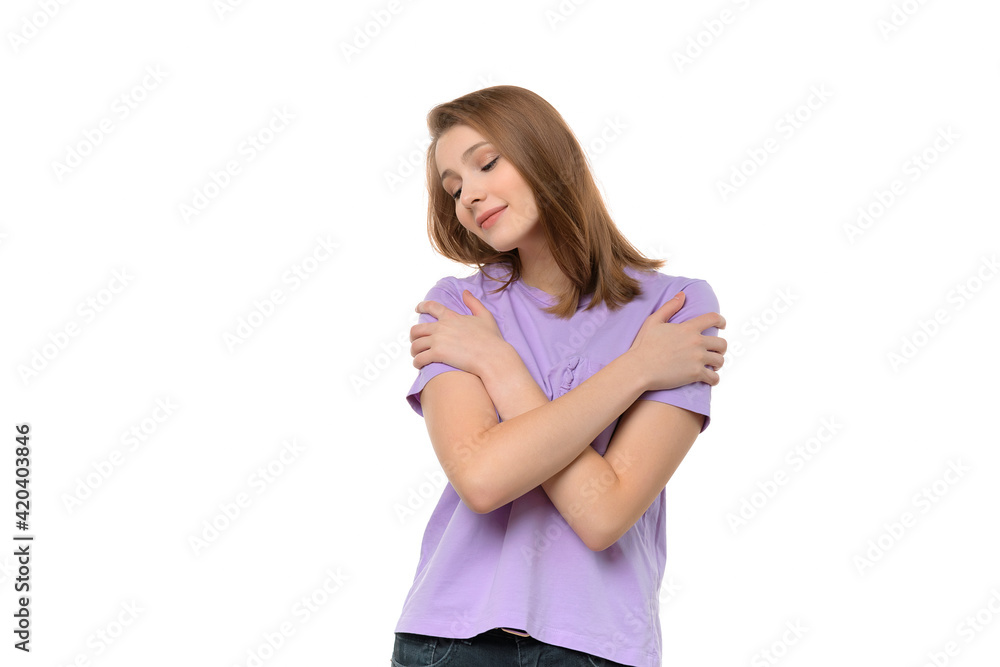 Happy cute girl embraces own body, expresses self love and care. Studio shot, white background Happy cute girl embraces own body, expresses self love and care. Studio shot, white background