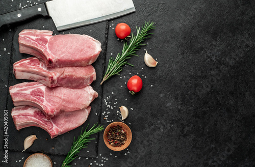 raw pork steaks on stone background with copy space for your text