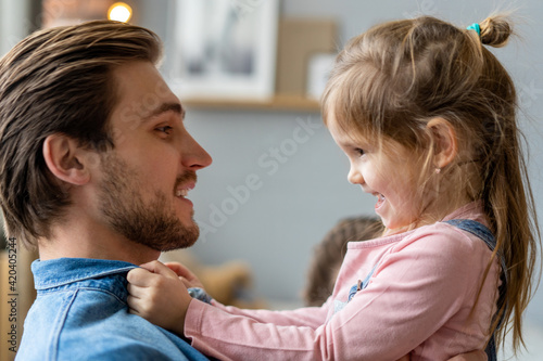 Portrait of handsome father and his cute daughter hugging and smiling.