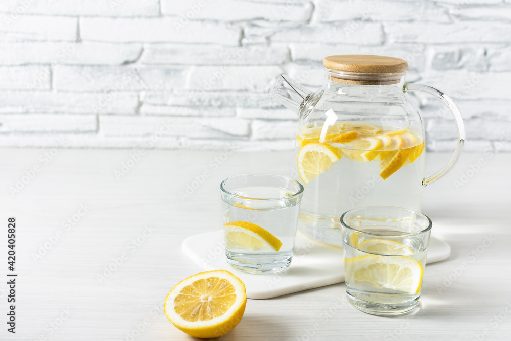 Lemon detox water in the morning on wooden background. Lemon detox water in the morning on wooden background.