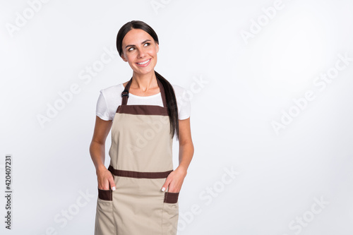 Portrait of pretty cheerful lady put hands in pockets look interested empty space isolated on white color background