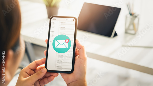 Woman hand holding smartphone and show email screen on application mobile in the office.