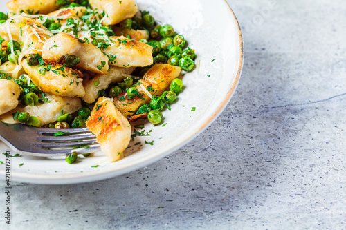 Gnocchi with peas, cheese and herbs. Italian cuisine concept.