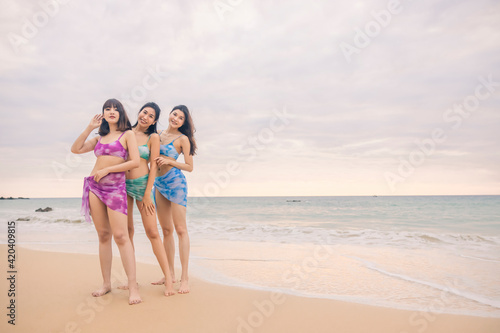 Three young women friends happily wear this bikini on a beach in Nai Thon Beach  Phuket Province  Thailand. Portrait of happy young woman smiling at sea. Concept about Travel  happiness  nature