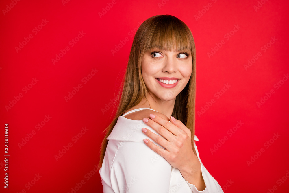 Profile side photo of young woman happy positive smile look empty space hand touch shoulder isolated over red color background Profile side photo of young woman happy positive smile look empty space hand touch shoulder isolated over red color background