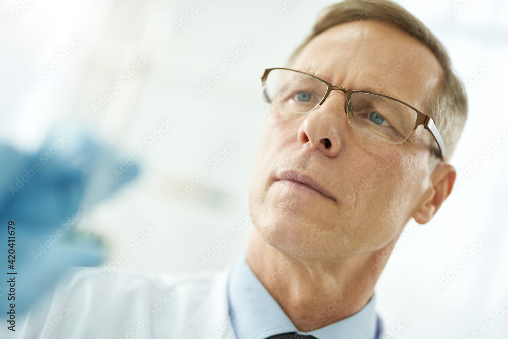 Handsome male doctor in glasses on white blurred background Handsome male doctor in glasses on white blurred background