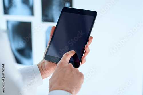 attending physician is using a digital tablet.