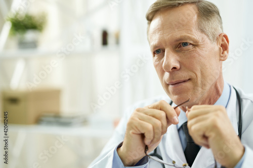 Handsome male doctor with glasses in his hands