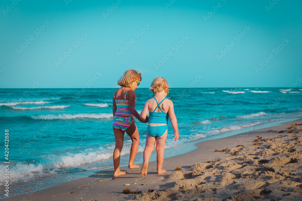 little girls walking on tropical beach, family at sea little girls walking on tropical beach, family at sea
