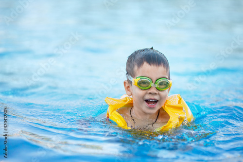 smiling little boy swims in the pool