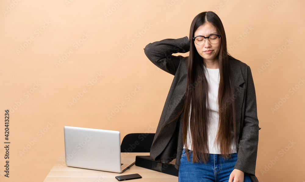 Chinese business woman in her workplace with neckache Chinese business woman in her workplace with neckache