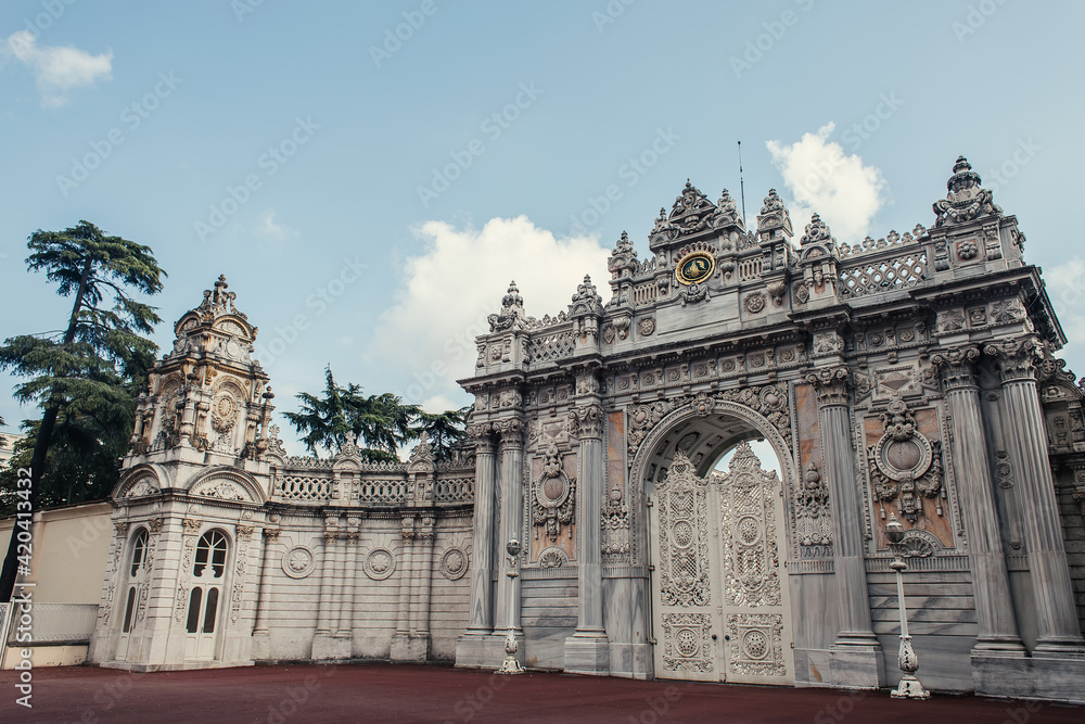 Gate of historical Dolmabahce palace and clouds in sky at background, Istanbul, Turkey
