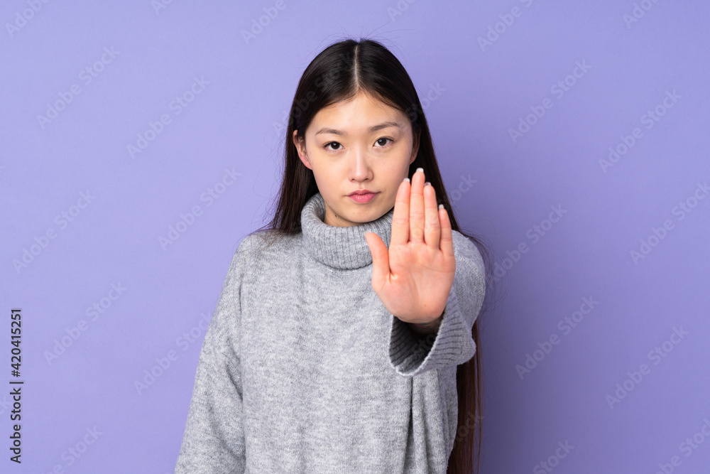 Young asian woman over isolated background making stop gesture Young asian woman over isolated background making stop gesture