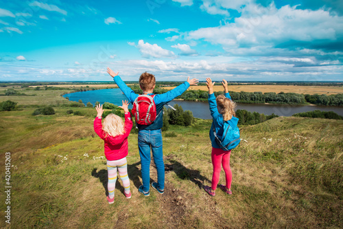 happy kids travel in nature, boy and girls enjoy scenic view