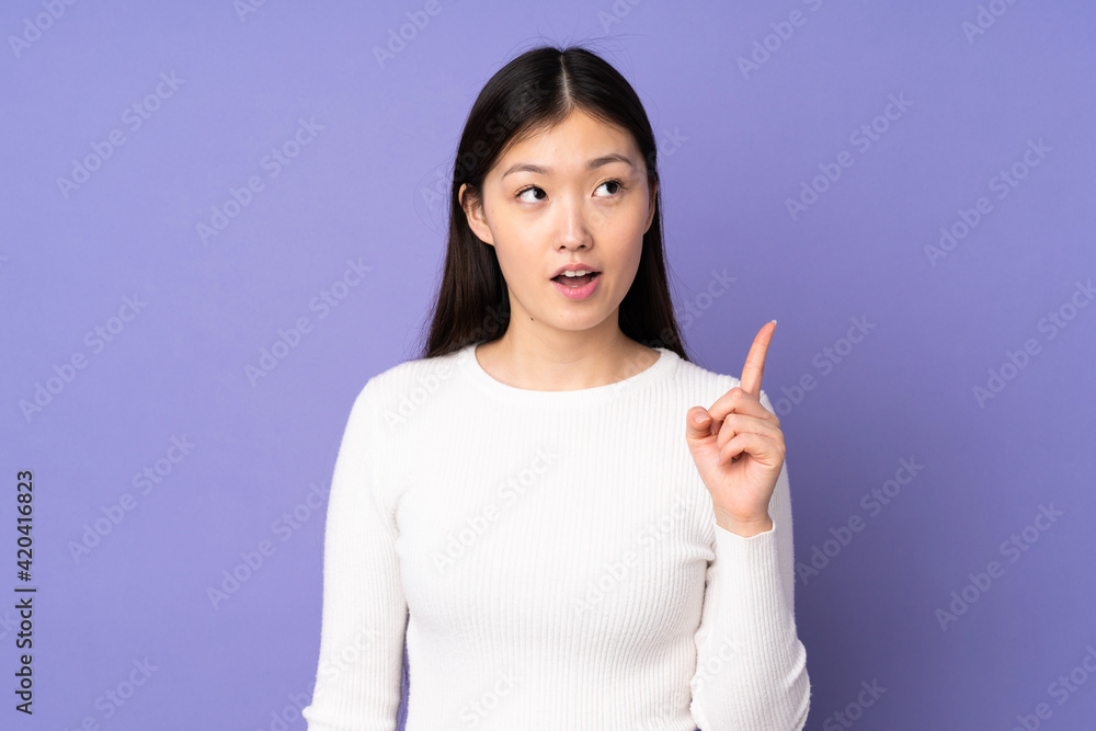Young asian woman isolated on purple background thinking an idea pointing the finger up Young asian woman isolated on purple background thinking an idea pointing the finger up
