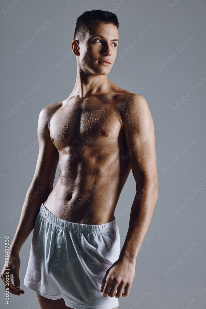 Fototapeta premium strong male athlete with flexed arm muscles on gray background cropped view