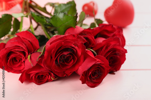 Beautiful red roses on pink table  closeup. Valentine s Day celebration