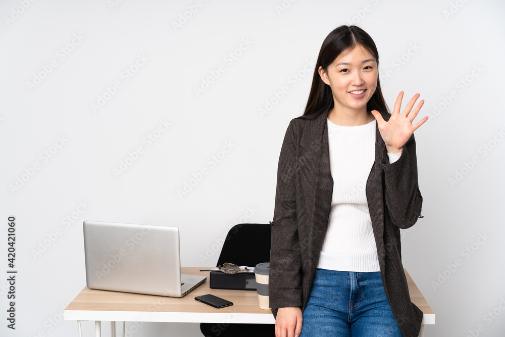 Business asian woman in her workplace isolated on white background counting five with fingers Business asian woman in her workplace isolated on white background counting five with fingers