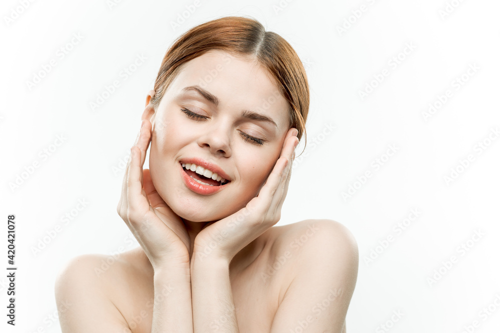 woman with closed eyes holds hands near face naked shoulders emotions light background woman with closed eyes holds hands near face naked shoulders emotions light background