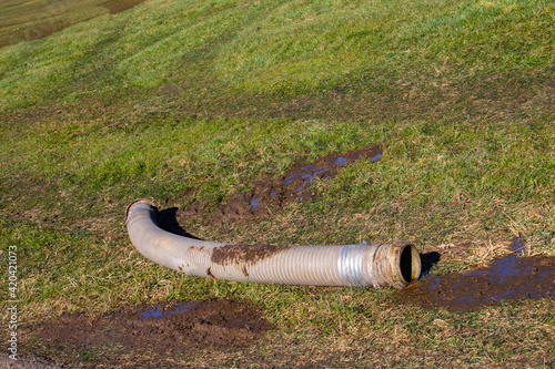 Wall Mural Big tube with slurry or manure is laying in the grass