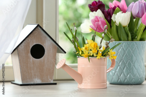 Photos Beautiful spring flowers with birdhouse on window sill