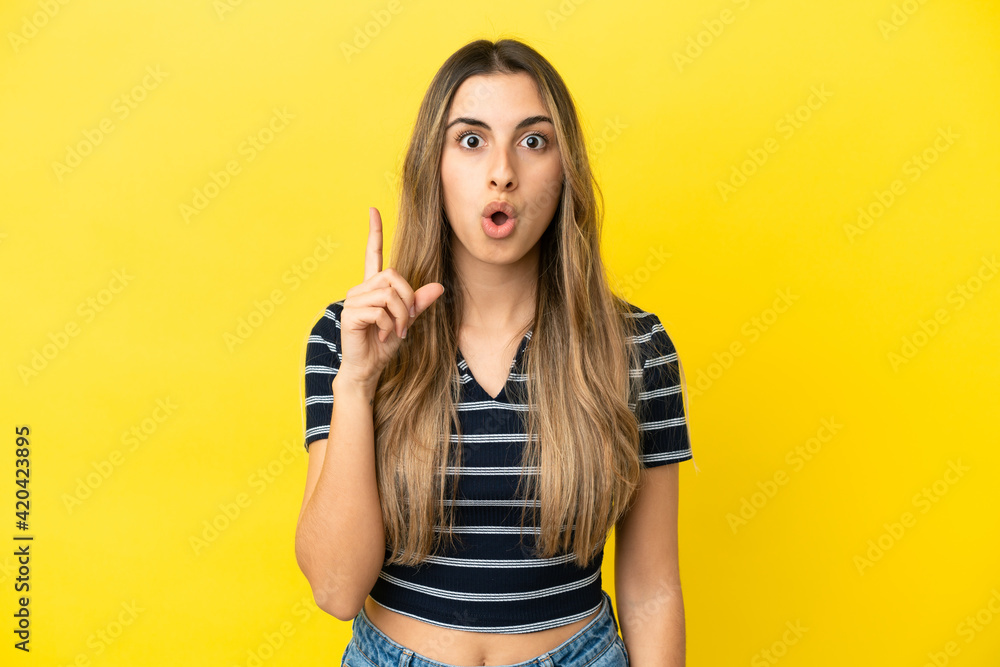 Young caucasian woman isolated on yellow background thinking an idea pointing the finger up Young caucasian woman isolated on yellow background thinking an idea pointing the finger up