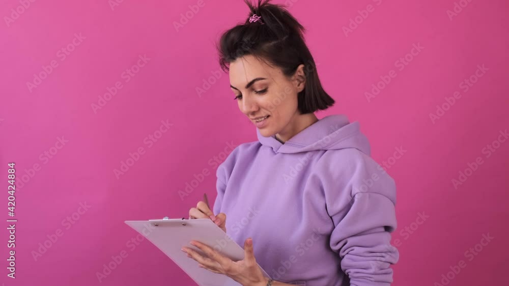 Caucasian woman isolated in casual purple shirt on pink background thoughtful think taking notes Caucasian woman isolated in casual purple shirt on pink background thoughtful think taking notes