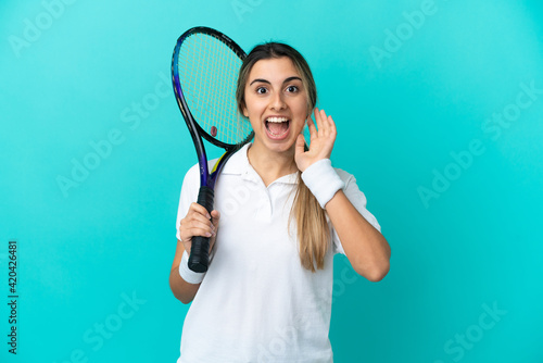 Young woman tennis player isolated on blue background with surprise and shocked facial expression