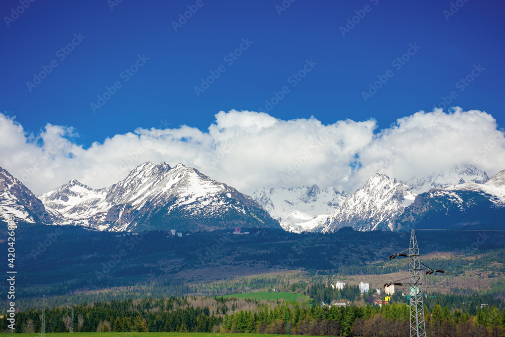 high tatra mountain ridge in springtime. cloud above the snow capped rocky peaks. beautiful sunny weather. wonderful nature scenery