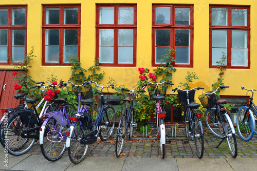 Bicycles parked on the background of the yellow building with many windows. Copenhagen, Denmark