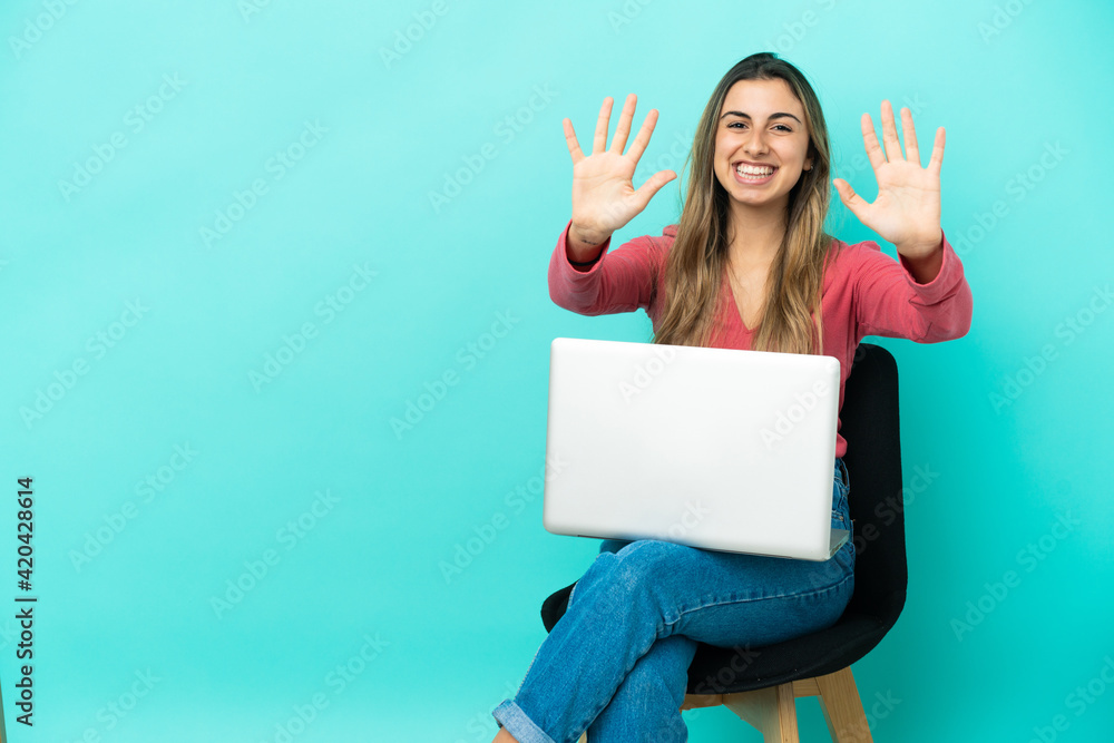 Young caucasian woman sitting on a chair with her pc isolated on blue background counting ten with fingers Young caucasian woman sitting on a chair with her pc isolated on blue background counting ten with fingers