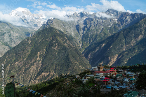 Kalpa village flanked by Himalayas and misty bright sky. Himachal Pradesh, India.