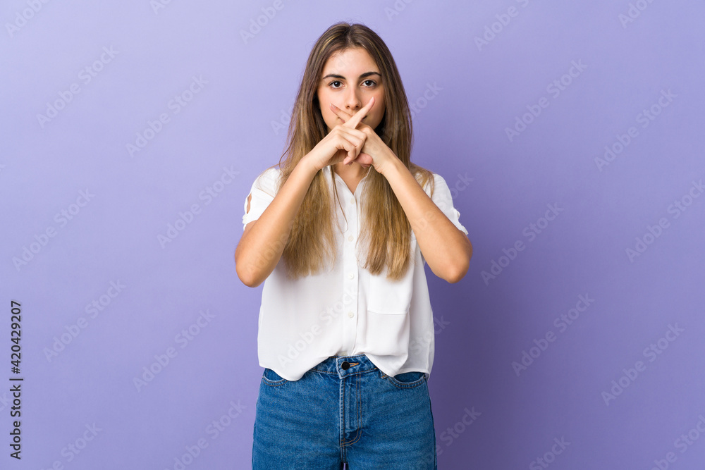 Young woman over isolated purple background showing a sign of silence gesture Young woman over isolated purple background showing a sign of silence gesture