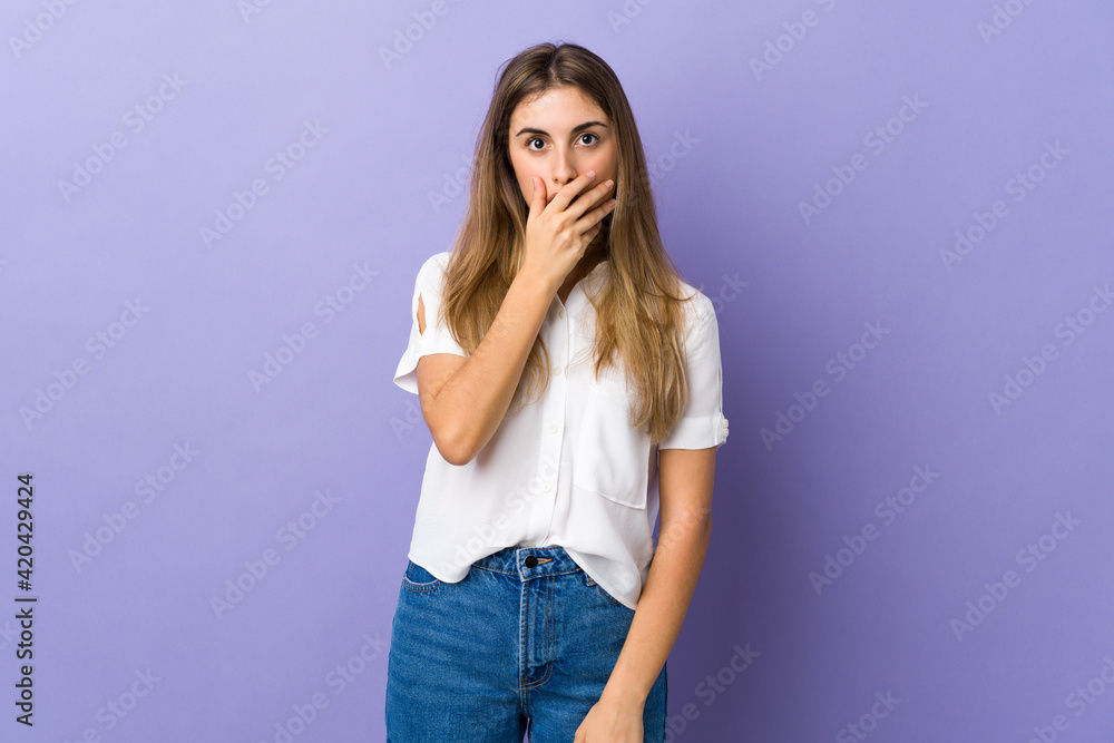 Young woman over isolated purple background surprised and shocked while looking right Young woman over isolated purple background surprised and shocked while looking right
