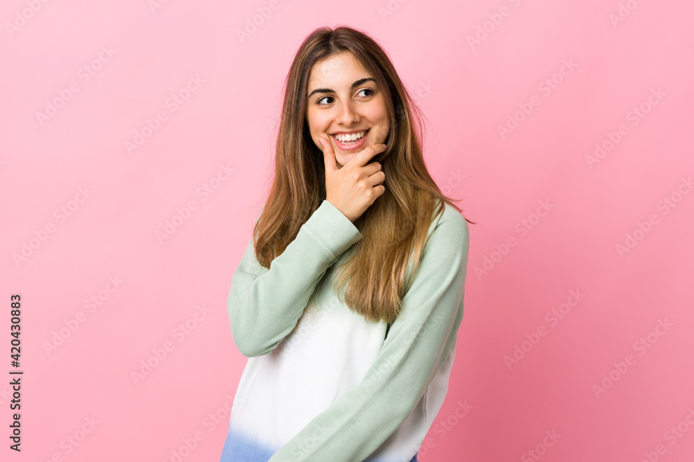 Young woman over isolated pink background looking to the side and smiling Young woman over isolated pink background looking to the side and smiling