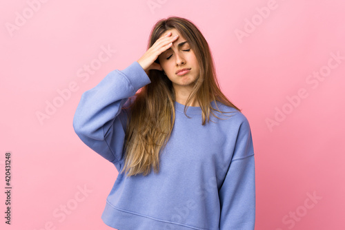 Young woman over isolated pink background with headache © luismolinero