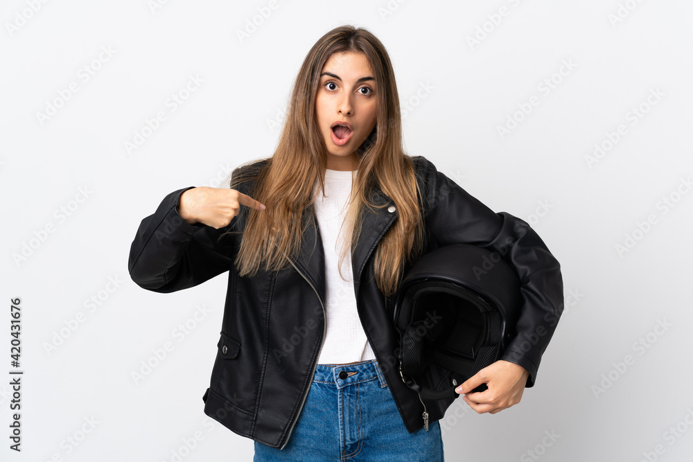 Young Woman holding a motorcycle helmet over isolated white background with surprise facial expression Young Woman holding a motorcycle helmet over isolated white background with surprise facial expression