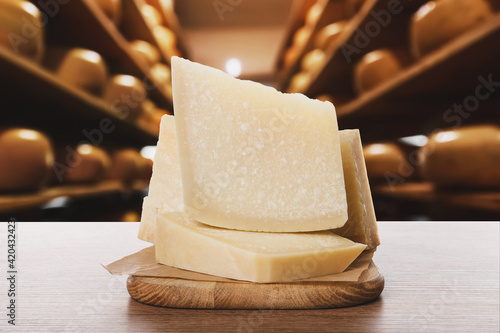 Delicious parmesan cheese on wooden table in warehouse