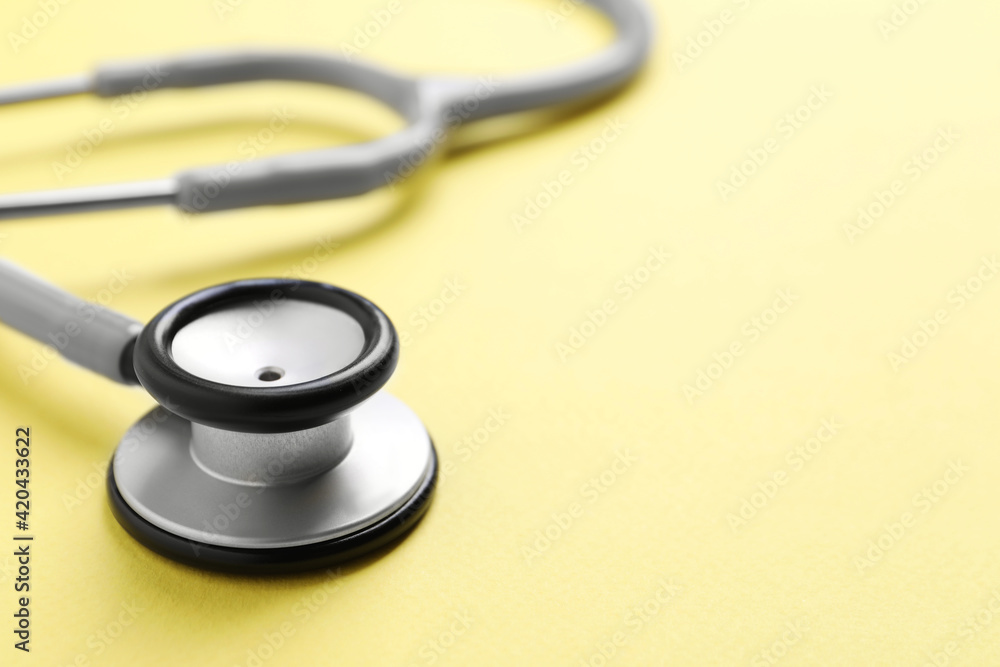 Stethoscope on yellow background, closeup. Space for text Stethoscope on yellow background, closeup. Space for text