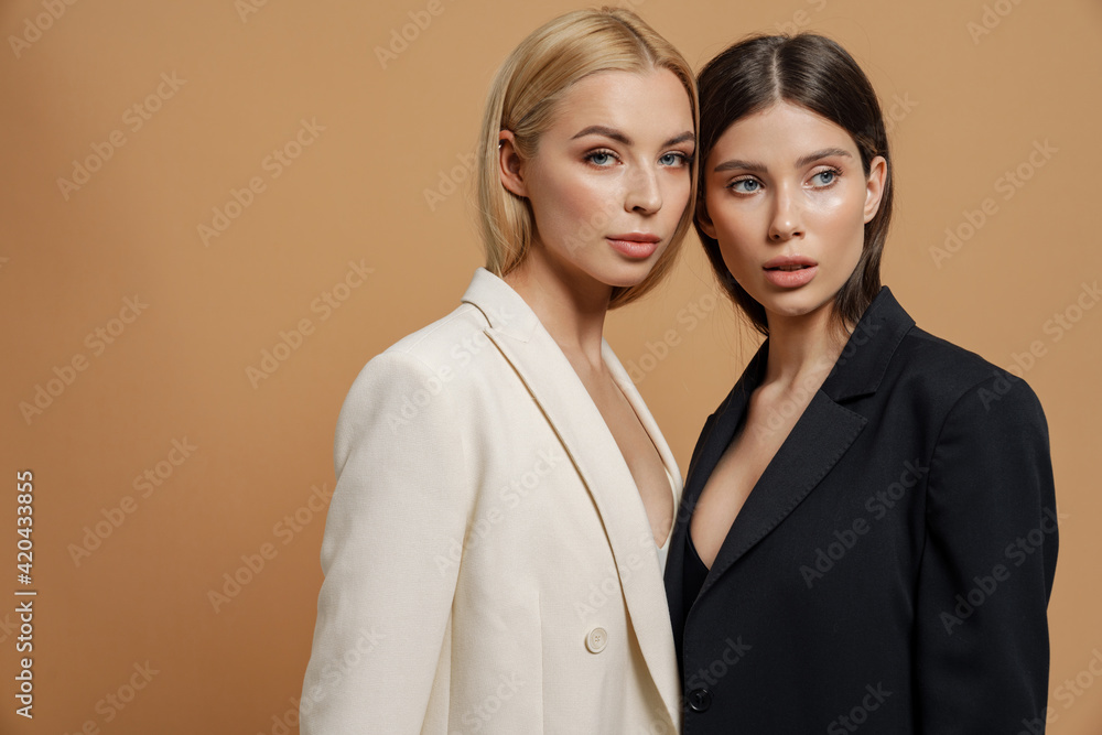 Two beautiful elegant women wearing smart jackets posing Two beautiful elegant women wearing smart jackets posing