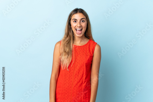 Young hispanic woman over isolated blue background with surprise facial expression