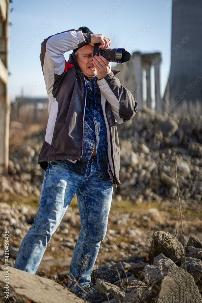 professional photographer taking pictures among industrial ruins