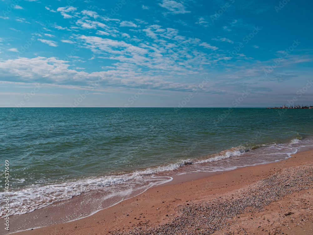 Obraz premium Empty beach with blue sea and sky background on a sunny day. South scenic landscape wallpaper, autumn winter sping summer vacation season. Vivid blue water with blurred copy space. Resorts advertising